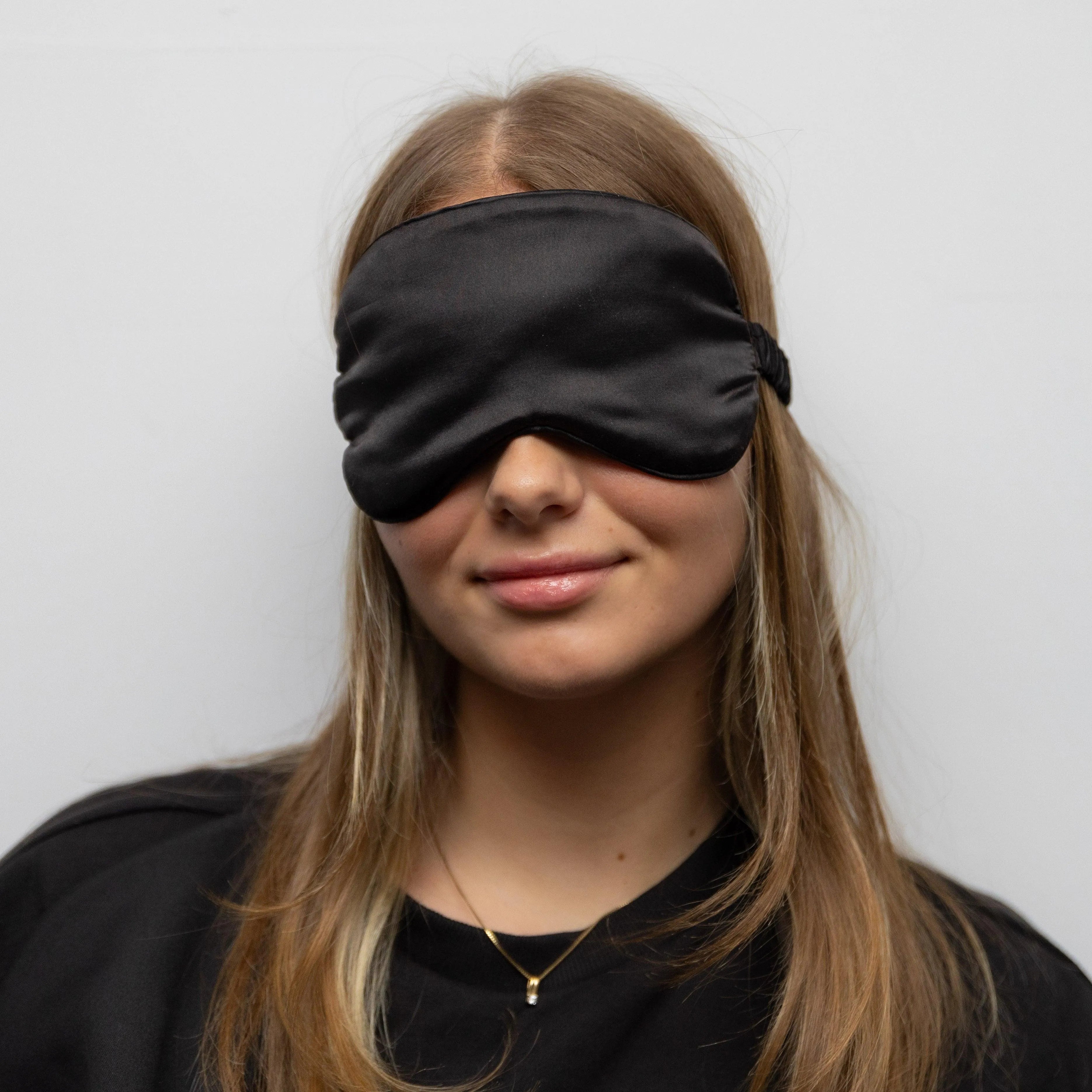 Model met het zwarte Alina zijde slaapmasker op.