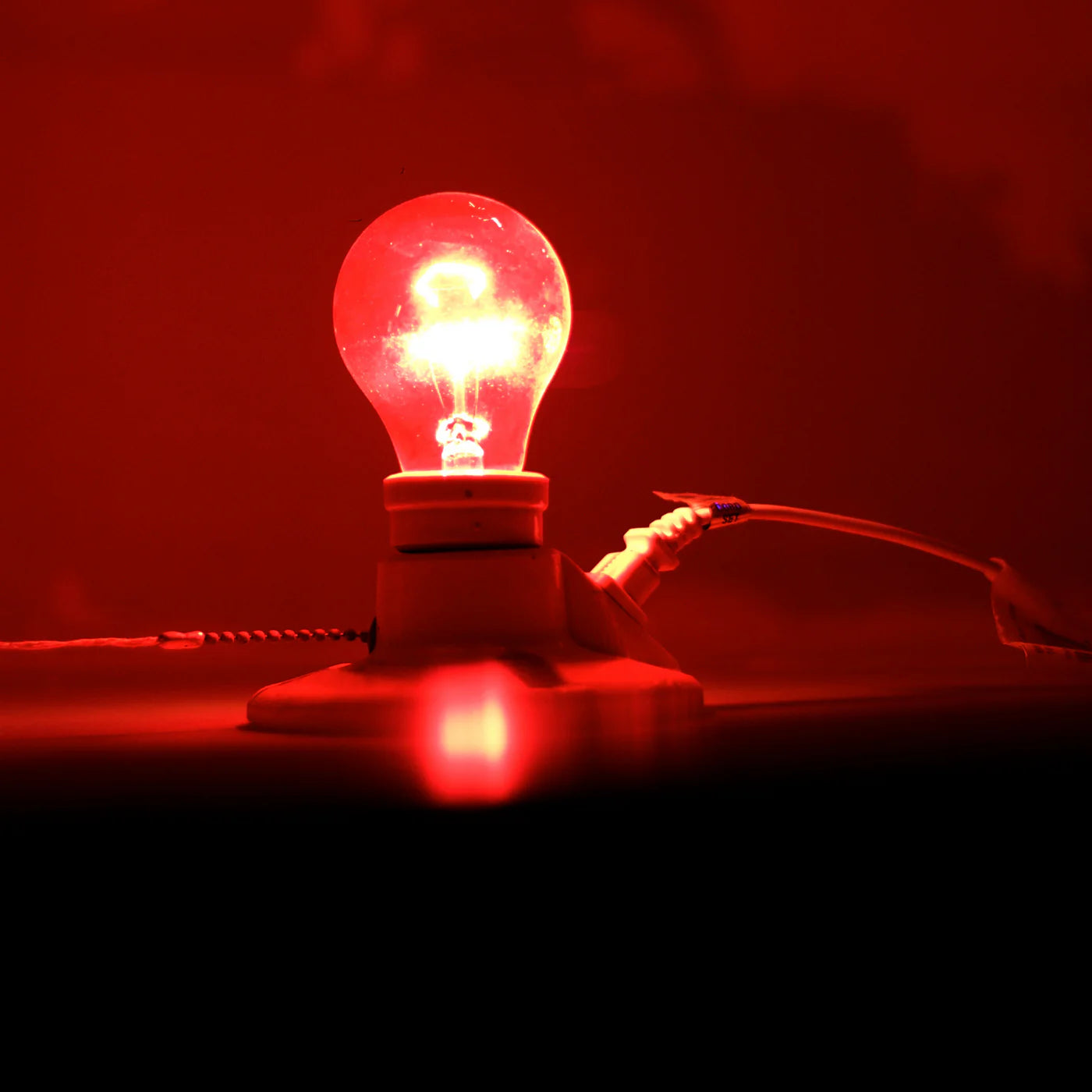 Rood licht lamp straalt helder in een donkere kamer, geplaatst op een tafel.